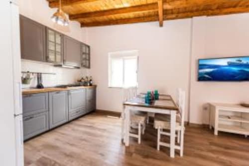 Cocina y comedor abiertos en apartamento Smart Rent Fuerteventura en Tarajalejo con vigas de madera y mobiliario moderno