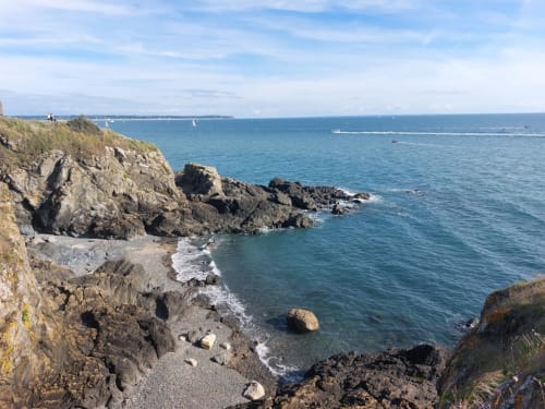 Petite crique rocheuse aux eaux turquoise près de Saint-Pair-sur-Mer, France