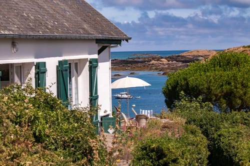 Petit cottage blanc aux volets verts surplombant la baie bleue à L'Écrin du Blanc Caillou, Saint Pair sur Mer