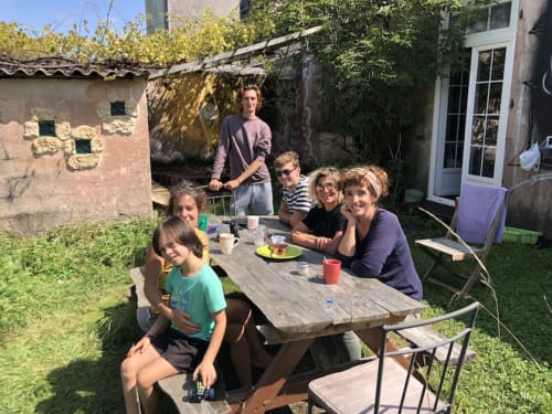 Family gathering at outdoor table in Penmarch garden, Le Lama Zébré guesthouse