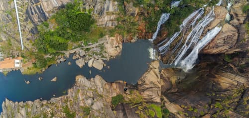 Aerial view of EcoHost's natural landscape in Perafita with waterfalls, rocky cliffs, and pristine pool