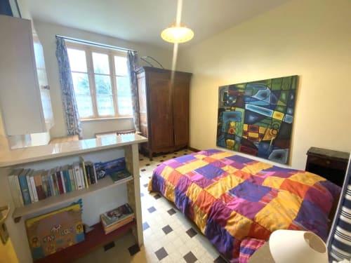 Colorful bedroom at Le Lama Zébré B&B in Penmarch with vibrant patchwork bedding and bookshelves