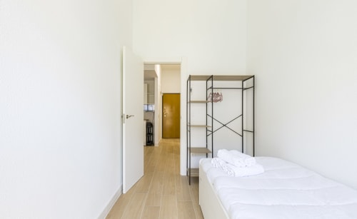 Dormitorio moderno con cama blanca y estructura metálica en el Numidas Open House Hotel de Murcia, España