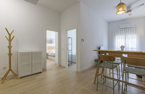 Moderna sala de estar con muebles de madera, mueblería blanca y vistas a la montaña en Murcia, España