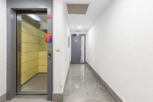 Pasillo moderno del Hotel Numidas Open House en Murcia con ascensor de puertas amarillas