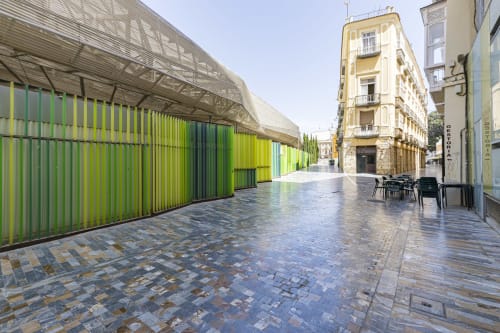 Plaza contemporánea del Numidas Open House Hotel en Murcia con arquitectura verde lima y edificios históricos amarillos