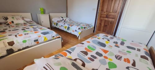 Tres camas con ropa de cama de colores en el apartamento La Viña 2 de Casas Rurales La Viña, Cuzcurrita de Río Tirón