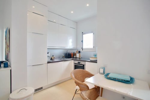 Modern white kitchen with dining area in Marbella seaview apartment at Puerto Banús