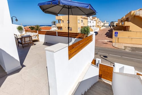 Terraza en azotea con sombrilla azul y zona de descanso con vistas a San Pedro del Pinatar y el Mar Mediterráneo