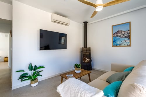 Moderno salón de apartamento en Haus Holiday Homes con estufa de leña, televisión y arte costero