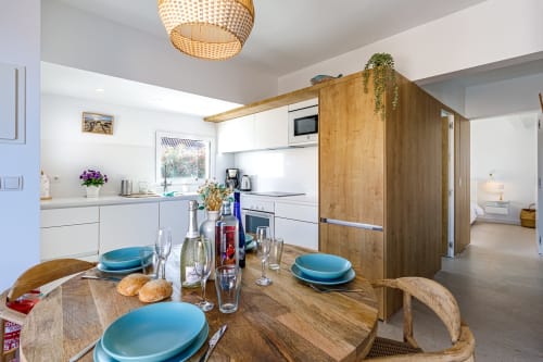 Moderna zona de cocina-comedor en apartamento Capila del Cabo de Haus Holiday Homes, San Pedro del Pinatar con mesa de comedor de madera