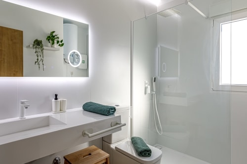 Baño moderno en Haus Holiday Homes de San Pedro del Pinatar con tocador blanco, espejo LED, ducha con mamparas de cristal