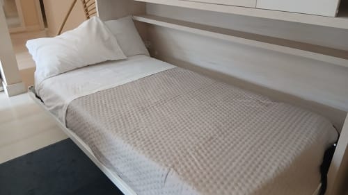Cama limpa com travesseiro branco e manta com textura em padrão de waffle no apartamento Sweet Home Litoral Mar, Portimão