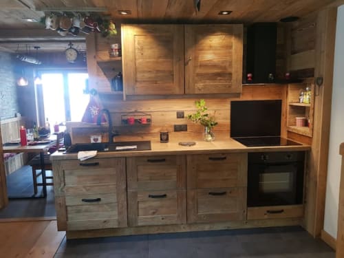 Cuisine rustique aux équipements modernes à Zoppas Courchevel, avec mobilier en bois naturel et ambiance lodge montagnard