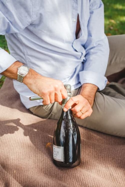 Man opening champagne bottle at Alessia's Place lakeside B&B in Como, Italy