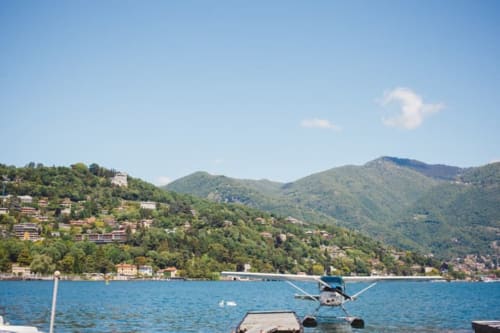 Seaplane docked on Lake Como with forested mountains and hillside villas in background, Alessia's Place, Como Italy