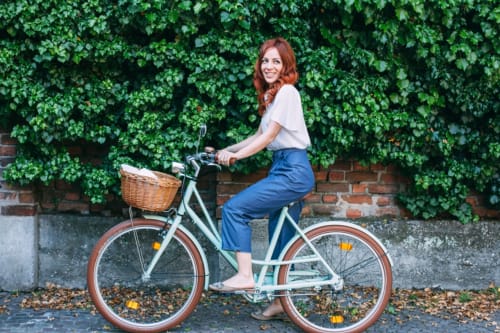 Woman on vintage bicycle with basket at Alessia's Place B&B in Como, Italy