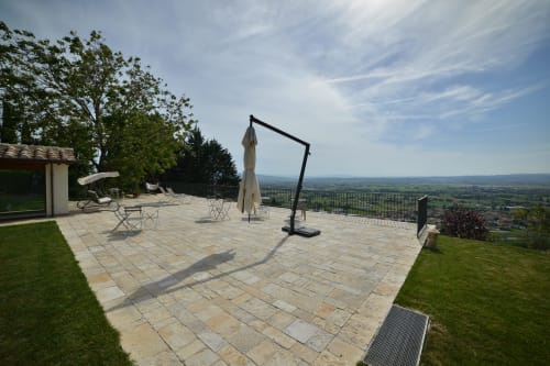 Terrazza della Proprietà Clara Assisi con patio, lettini, ombrellone e vista panoramica sulla valle