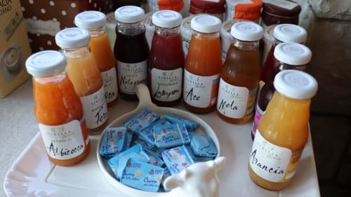 Marmellate e succhi di frutta fatti in casa da Proprietà Clara ad Assisi, Italia, disposti con bustine di burro
