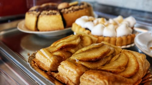 Vetrina di pasticceria dell'hotel Proprietà Clara ad Assisi con crostate alla crema e dolcetti al cioccolato