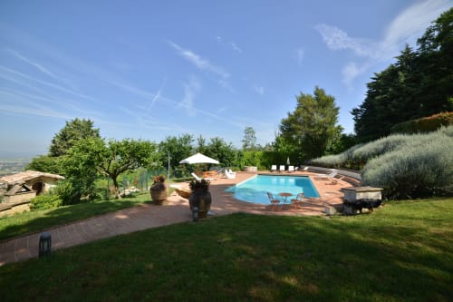 Piscina e giardini di Proprietà Clara ad Assisi con terrazza in cotto, ulivi e vista sulla valle