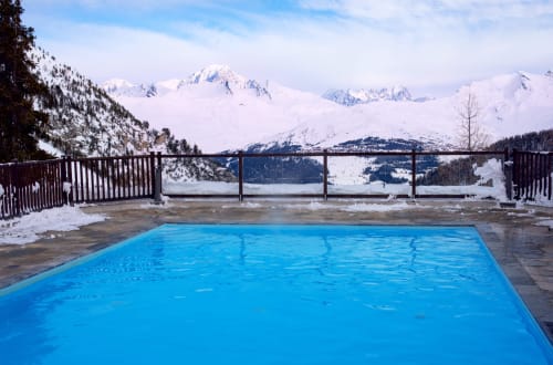 Piscine chauffée extérieure à Zoppas Courchevel avec les sommets alpins enneigés en arrière-plan