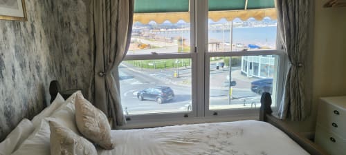 Double bedroom with sea view at The Sands Hotel in Paignton, featuring bed, desk, and coastal outlook