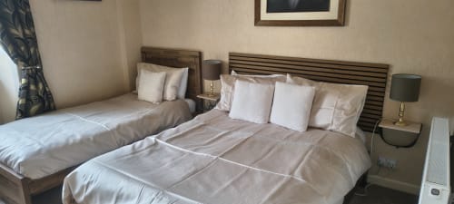 Triple room at The Sands Hotel Paignton with two beds, white bedding, side lamps, and garden view