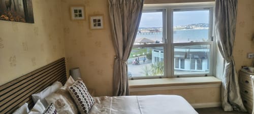 Deluxe Double Room at The Sands Hotel Paignton with sea view, double bed, and windows overlooking beach