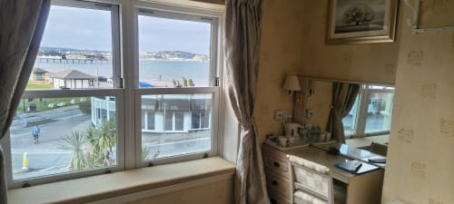 Deluxe sea view room at The Sands Hotel in Paignton with window overlooking beach and coastline