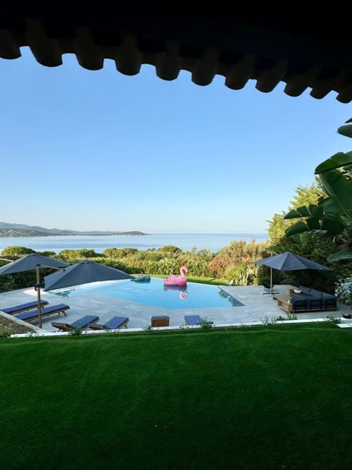 Villa di lusso con piscina a sfioro con vista sul mare a Porticcio, Corsica, con ombrelloni blu e prato curato
