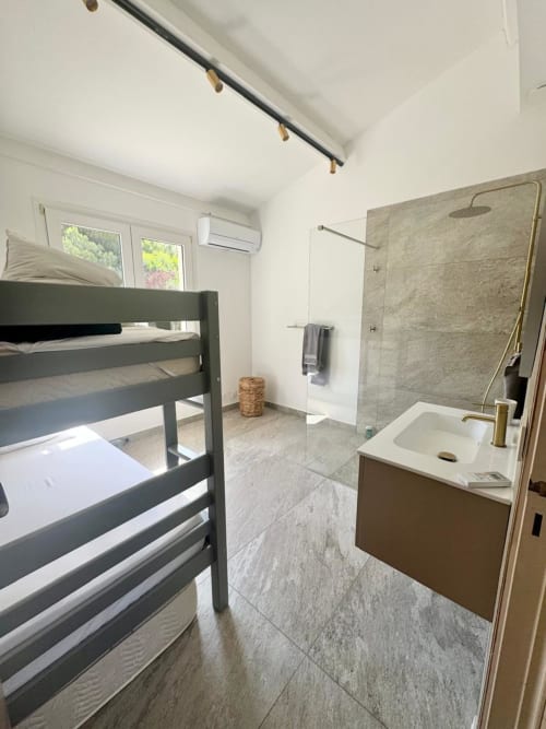 Moderno bagno con letti a castello, doccia walk-in e pavimenti in marmo presso la villa Conciergerie De Porticcio, Porticcio