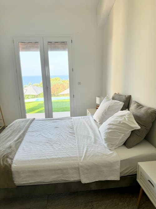 Camera da letto con porte vista mare della villa Conciergerie De Porticcio, affacciata sul paesaggio mediterraneo e sulla piscina