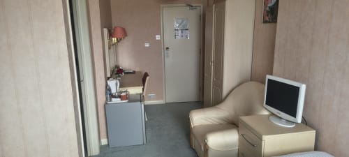 Triple room at The Sands Hotel, Paignton with beige furnishings, TV, desk, and entry door