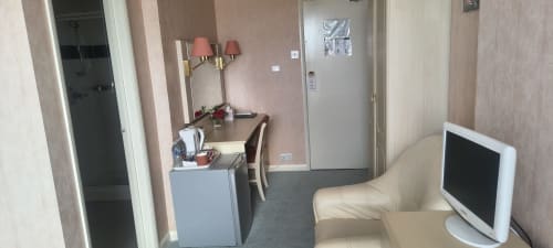 Triple room at The Sands Hotel in Paignton featuring desk with lamp, flat screen TV, and beige seating area