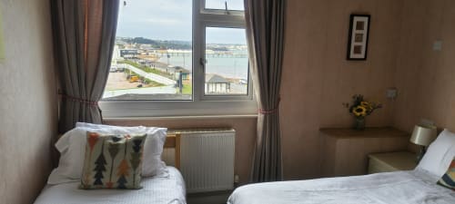 Twin beds in Sands Hotel sea view room, Paignton, with harbor views from window and coastal scenery