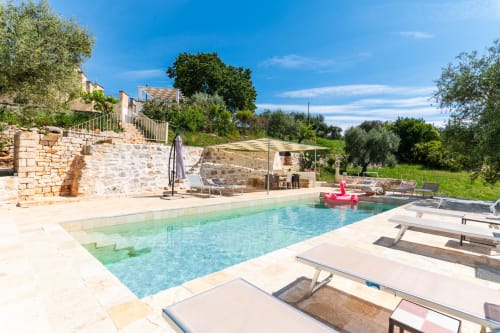 Villa Trulli Life con piscina scintillante, lettini, architettura in pietra e vista sulla campagna pugliese di Bari
