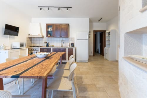 Cucina moderna e zona pranzo nella villa Trullo Il Sassofono al Trulli Life hotel di Bari, Italia, con tavolo in legno