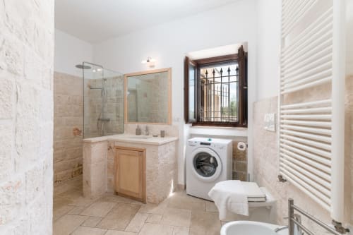 Bagno moderno nella villa Trulli Life con doccia walk-in, vanity, lavatrice e finestra a Bari