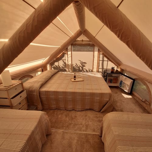 Intérieur spacieux de tente familiale au Baia Dorica Camping Village avec lit, mobilier et lumière naturelle