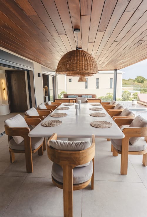 Pavillon de dining contemporain de la villa Blue Horizon Collection à Saint-François avec chaises en bois, suspension en rotin et vue sur mer