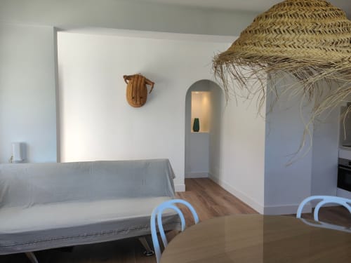 Apartamento de lujo Nido Anaga en Tenerife con sofá beige, nicho arqueado y decoración de paja tejida