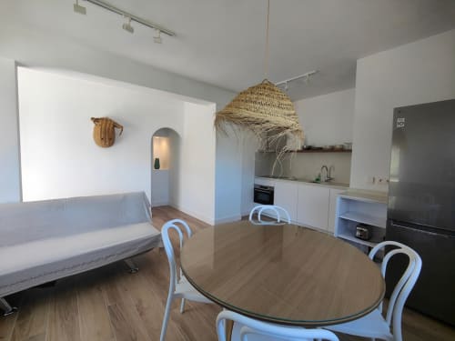 Moderno apartamento en Nido Anaga con mesa de comedor, cocina, sofá y lámpara colgante tejida en Santa Cruz de Tenerife.