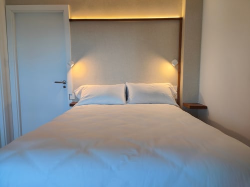 Modern bedroom at Nido Anaga hotel in Tenerife with white bedding, ambient lighting, and minimalist design