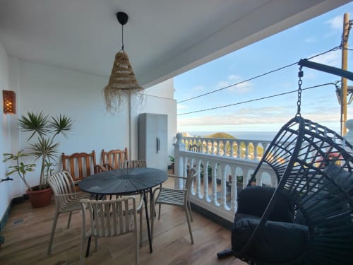 Nido Anaga terrace with sea view, hanging nest chair, dining table, and coastal landscape in Tenerife