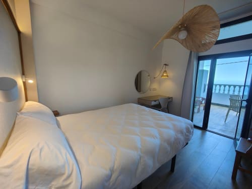 Dormitorio moderno en Nido Anaga con terraza vista al mar, diseño minimalista y silla nido de diseñador en Tenerife