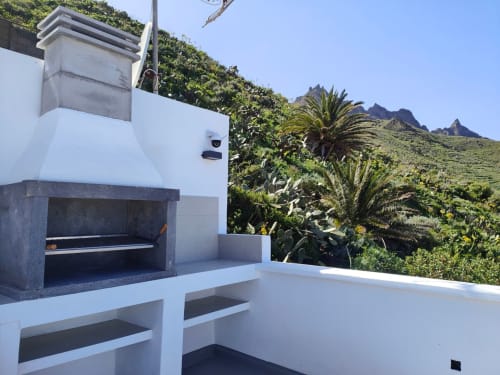 Modern terrace at Nido Anaga with outdoor grill, mountain views, and tropical plants in Tenerife