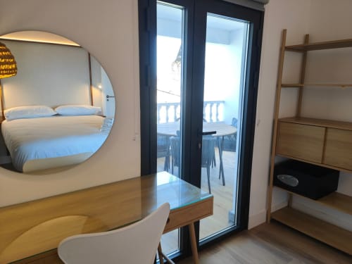 Apartamento moderno en Nido Anaga con espejo circular, escritorio de madera, estantería y balcón con vistas al mar en Tenerife