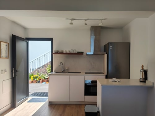 Cocina moderna en el apartamento Nido Anaga de Tenerife con vista al patio y electrodomésticos negros