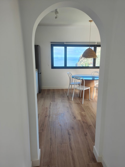 Entrada arqueada hacia la zona de comedor con vistas al océano en el apartamento Nido Anaga de Tenerife